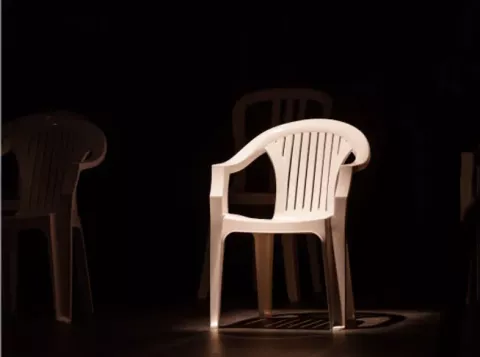 White chair lit on black background